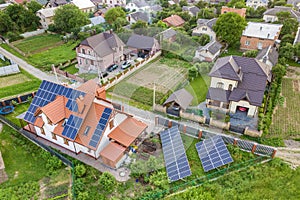 Aerial top view of new modern residential house cottage with blue shiny solar photo voltaic panels system on roof. Renewable