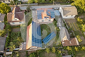 Aerial top view of new modern residential house cottage with blue shiny solar photo voltaic panels system on roof. Renewable