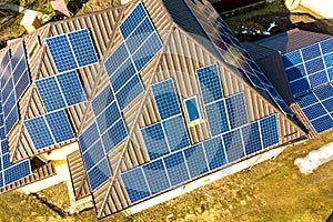 Aerial top view of new modern residential house cottage with blue shiny solar photo voltaic panels system on roof. Renewable