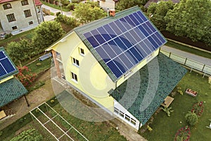 Aerial top view of new modern residential house cottage with blue shiny solar photo voltaic panels system on roof. Renewable