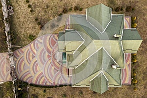 Aerial top view of new residential house cottage with shingle roof on fenced big yard on sunny day