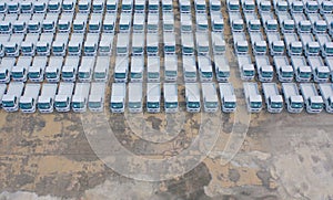 Aerial top view of new truck cars parking for sale stock lot row, dealer inventory import and export business commercial,