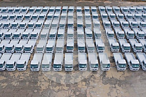 Aerial top view of new truck cars parking for sale stock lot row, dealer inventory import and export business commercial,