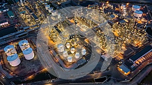 Aerial top view oil and gas tank with oil refinery background at night, Business petrochemical industrial, Refinery factory oil