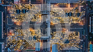 Aerial top view oil and gas tank with oil refinery background at night, Business petrochemical industrial, Refinery factory oil