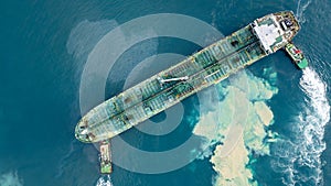 Aerial top view oil tanker ship at terminal industrial port tugboat drag crude oil tanker ship park to port for transfer crude oil