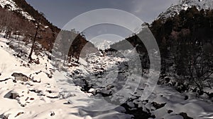 Aerial top view over snow-covered coast mountain river stream. Winter landscape of nature nobody. The natural beauty of