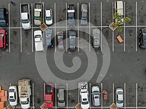 Aerial top view of parking with varieties of colored vehicles