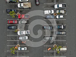 Aerial top view of parking with varieties of colored vehicles