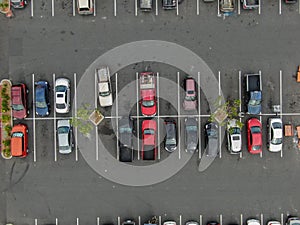 Aerial top view of parking with varieties of colored vehicles