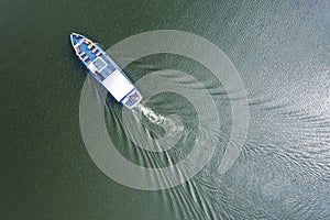 Aerial top view photo of small motor boat cruising on the river