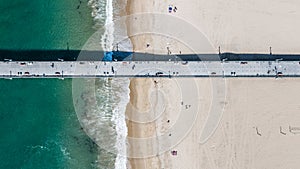 Aerial top view of a pier construction which protrudes into the water,