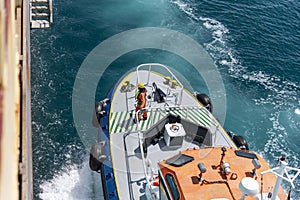 Aerial, top view on the pilot boat - deckhand preparing safe way for navigational pilot to enter cargo ship photo