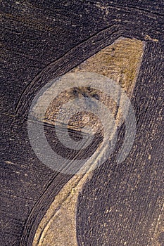 Aerial top view of plowed field and meadow