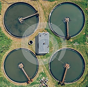 Aerial top view of polls in wastewater treatment plant, filtration of dirty or sewage water. Four circles.
