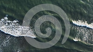 Aerial top view powerful waves on blue turquoise ocean crashing and foaming. Drone 4K footage sunny day over the stormy