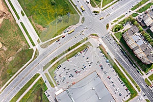 Aerial top view of residential area with shopping mall, cars on parking lot, car traffic on street