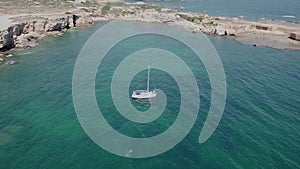 Aerial Top View of a sailboat in blue water