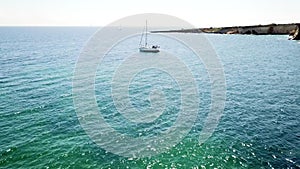 Aerial Top View of a sailboat in blue water