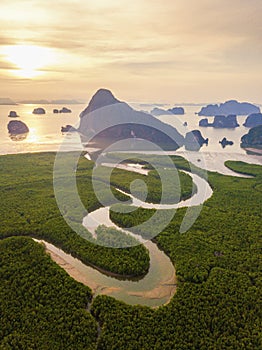 Aerial top view of Samet Nangshe, mountain valley hills, and tropical green forest trees at sunset with Andaman sea in Phang Nga