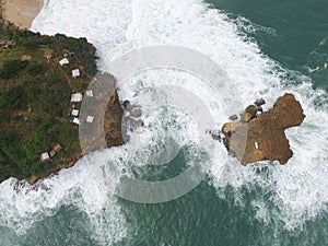Aerial top view of sea calm waves hitting rocks