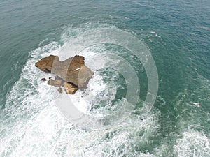 Aerial top view of sea with waves hitting rocks