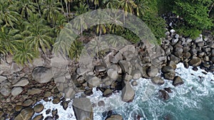 Aerial top view of sea waves hitting rocks on the beach in Phuket