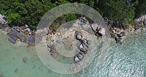 Aerial top view of sea waves hitting rocks on the beach in Phuket