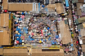 Aerial top view shot of a bunch of people holding umbrellas walking in a market in Ghana