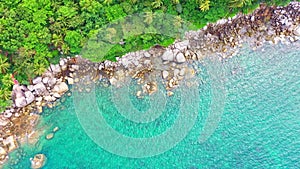 aerial top view smooth waves in Phuket sea hit on the rocks.