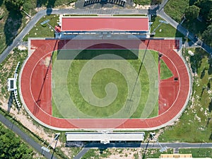 Aerial top view on a soccer field, grandstand, football field with red running track. race track in a stadium.