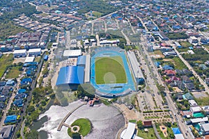 Aerial top view of soccer football sport recreation field ground, national stadium. Urban city town in Asia. Green court arena