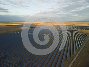 Aerial top view of a solar panels power plant. Photovoltaic solar panels at sunrise and sunset in countryside from above
