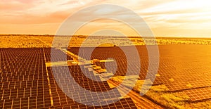 Aerial top view of a solar panels power plant. Photovoltaic solar panels at sunrise and sunset in countryside from above