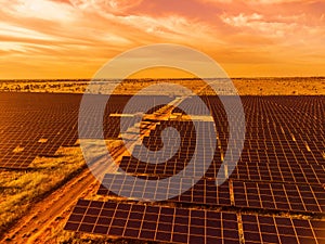 Aerial top view of a solar panels power plant. Photovoltaic solar panels at sunrise and sunset in countryside from above