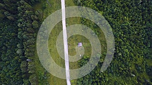 Aerial top view of summer green trees, river, roads in forest background. Aerial view of crooked path of road on the