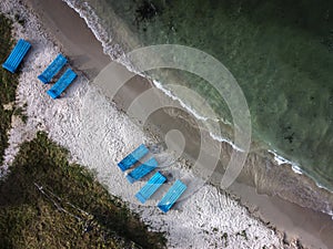 Aerial top view of sun lounger near the coastline.