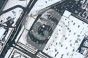 Aerial top view of supermarket parking lot in winter season