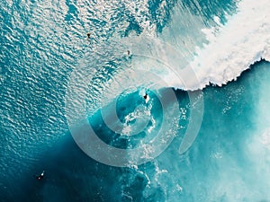 Aerial top view of surfing at barrel waves. Blue waves and surfers