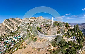 Aerial top view to village Gunib and famous attraction Memorial White cranes in Victory Park. Famous village among the