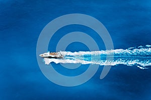Aerial top view of tourist speed boat sailing in the deep blue sea