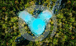 Aerial top view of turquoise lagoon shaped heart inside of tropical island. Love travel summer vacation concept