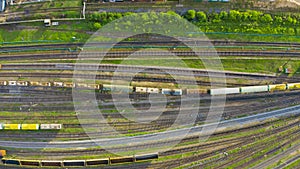 Aerial top view of various railway carriage trains with goods on the railway station, freight train departure