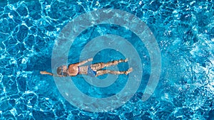 Aerial top view of woman in swimming pool water from above, tropical vacation holiday