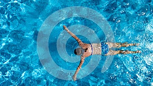 Aerial top view of woman in swimming pool water from above, tropical vacation holiday