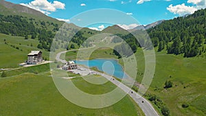 AERIAL: Tourists on motorbikes ride along the scenic road towards the lake.