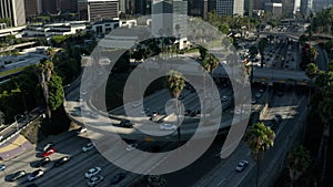 AERIAL: Toward Downtown Los Angeles, California intersection traffic with palm trees and Skyline in background at