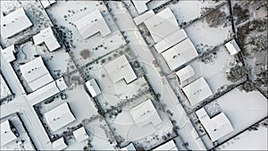 Aerial. Townhouse settlement in winter. Snow covered rooftops of cottages. Top view