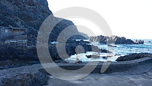 Aerial tracking shot girl running on promenade between lava and ocean