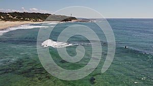 aerial tracking shot of a longboard surfer at pebbly beach